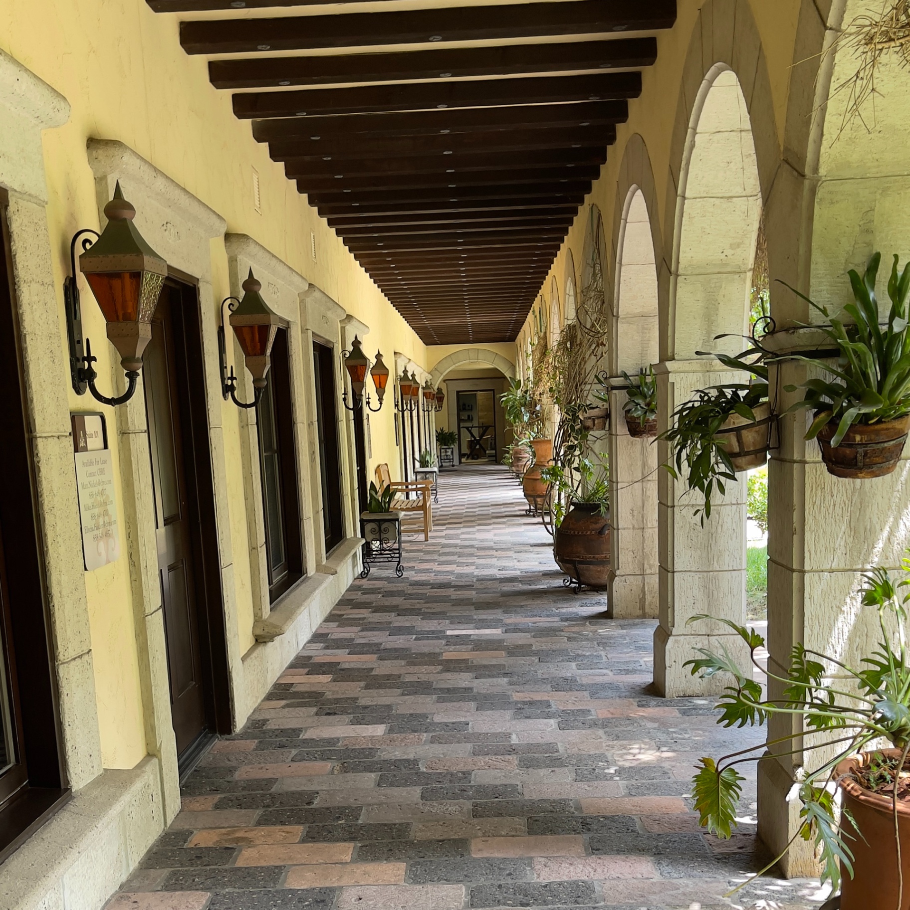 Exterior arched corridor and landscaped walkway of the property at 12625 High Bluff Drive, where the practice office is located